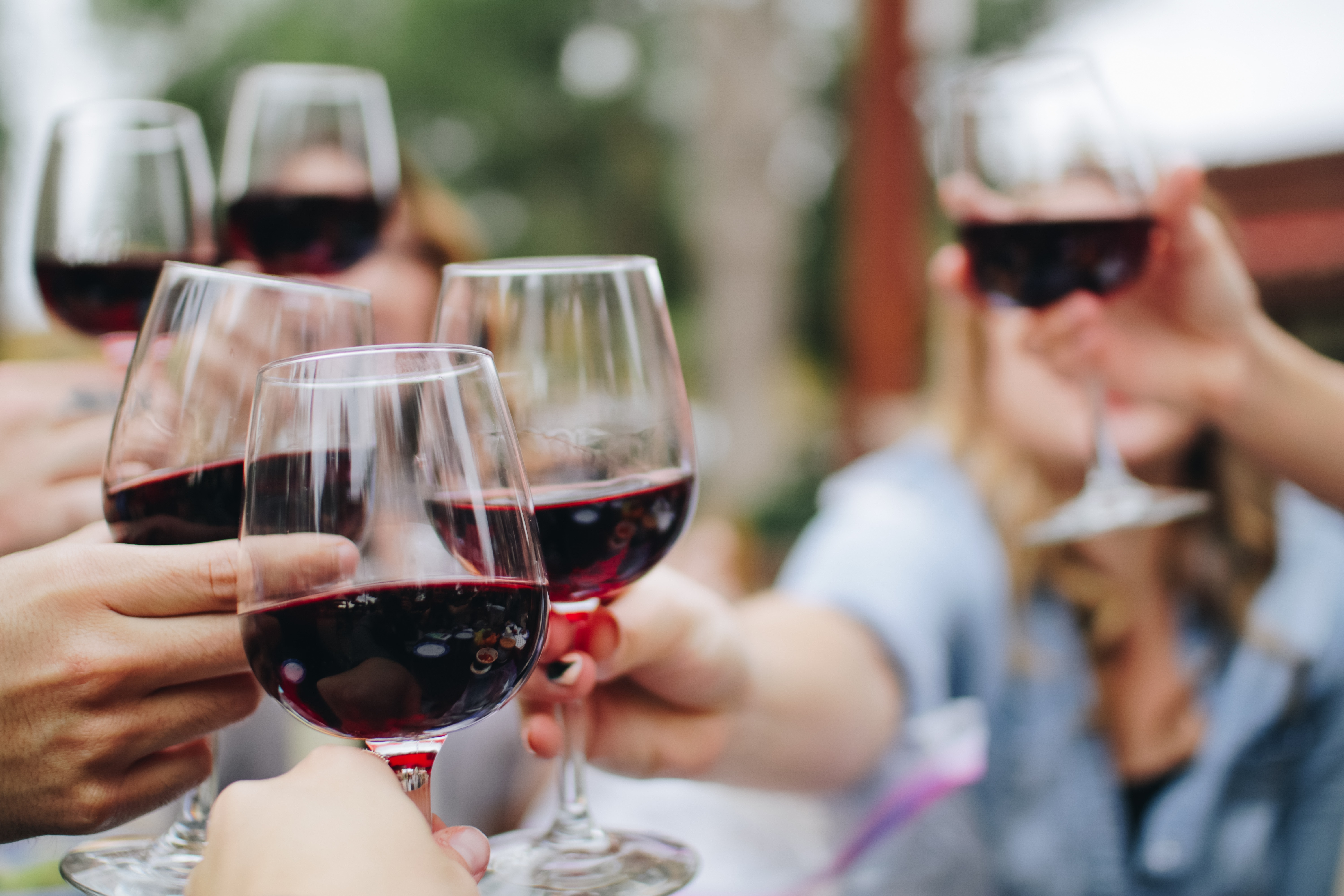 Glasses of red wine held up to do cheers