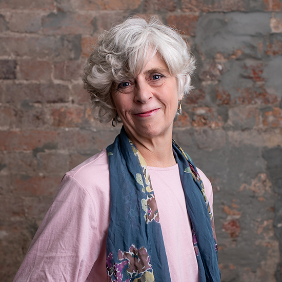 Karen smiling in front of a brick wall