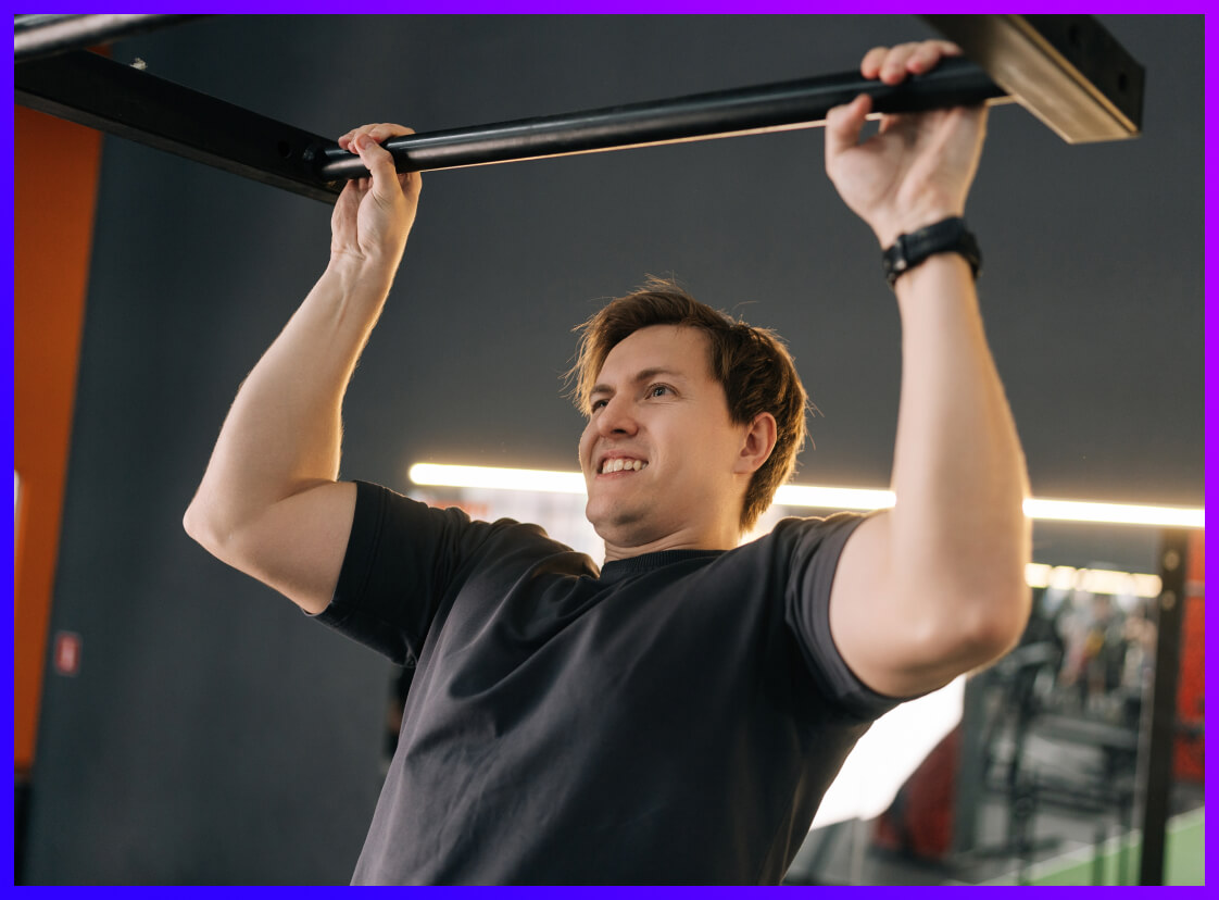 Person taking part in the Hold on Challenge in a gym - holding onto a bar