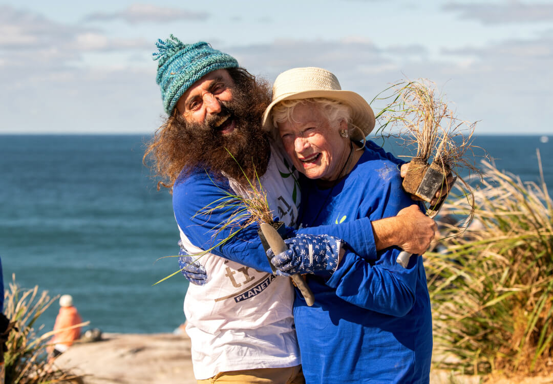 Costa Georgiadis with tree planting participant wearing blue.