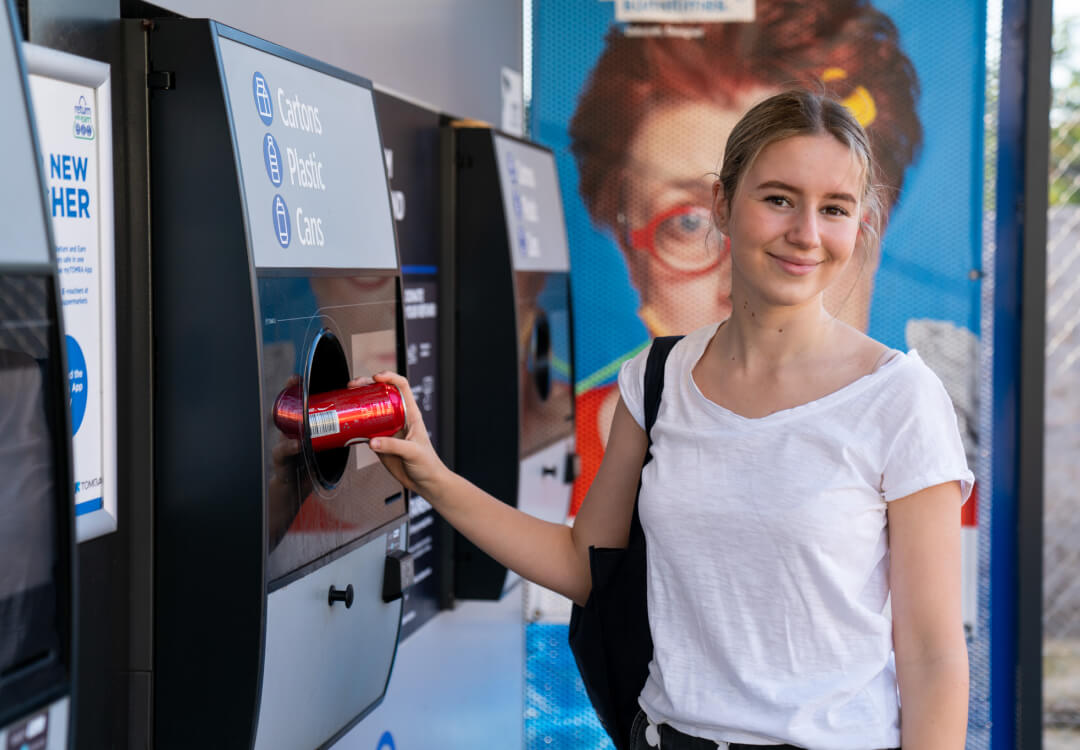 Young woman recycling a drinks can.