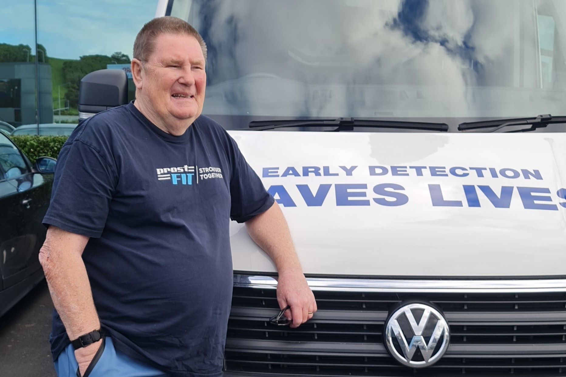 Doug smiling standing next to a Prostate Cancer Foundation van.